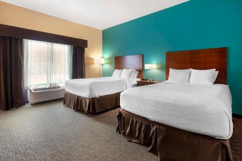 a hotel room with two beds and a blue wall at Best Western Plus French Lick in French Lick