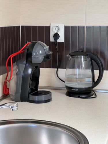 a coffee maker sitting on a counter next to a tea kettle at Sunny Bay Apartments in Španjola