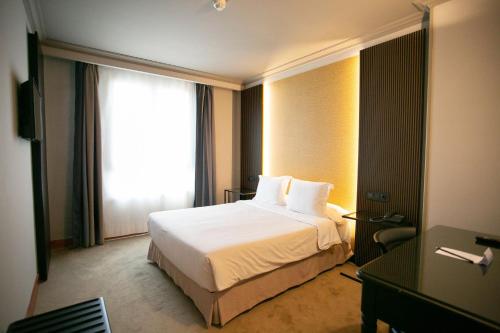 a hotel room with a bed and a window at Hotel Sercotel Ciudad de Oviedo in Oviedo