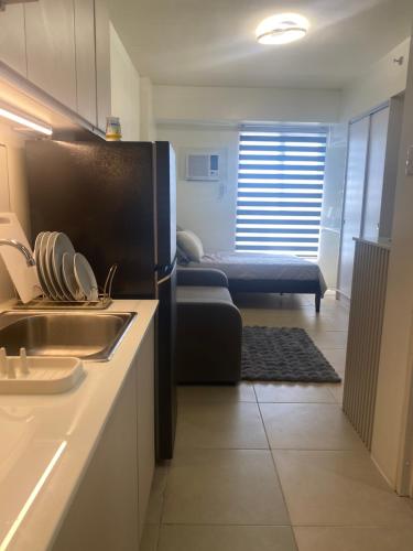 a kitchen with a sink and a couch in a room at B & M Condo near NAIA Airport and SM Mall in Manila