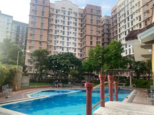a swimming pool in front of some tall buildings at B & M Condo near NAIA Airport and SM Mall in Manila