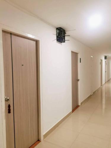 an empty hallway with white walls and white floors at Ratanasiri Hotel in Chaiyaphum