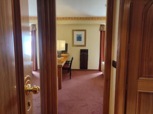 a hallway with a room with a desk and a computer at Hotel Sercotel Cuatro Postes in Avila