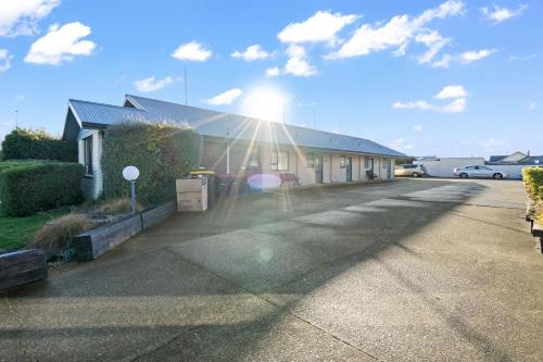 a building in a parking lot with the sun shining at CITY COURT by KTC in Invercargill