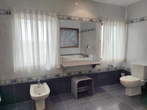a bathroom with a toilet and a sink and a tub at Hotel Sercotel Cuatro Postes in Avila