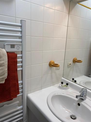 une salle de bain blanche avec un lavabo et un miroir dans l'établissement Escapade iodée à la Naturelle Vue mer- Wifi- Wimereux Côte d'opale, à Wimereux