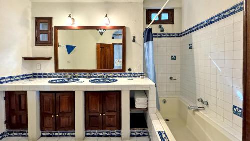 a bathroom with a sink and a mirror and a tub at Departamentos en SF - Adults Only in Playa del Carmen