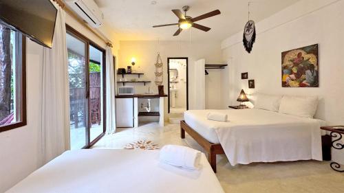 a bedroom with two beds and a ceiling fan at Departamentos en SF - Adults Only in Playa del Carmen