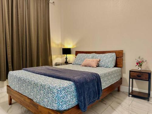 a bedroom with a bed with a blue comforter at New Renovated House in Little Saigon in Midway City