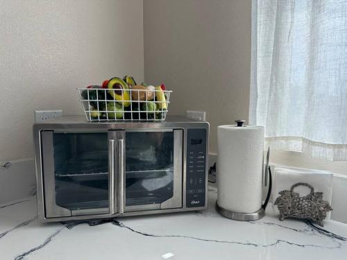 a microwave with a basket on top of it on a counter at New Renovated House in Little Saigon in Midway City