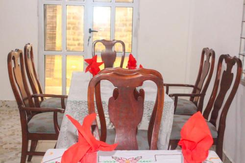 a dining room table with red bows on the chairs at Résidences Hôtel Perle Bleue in Cotonou