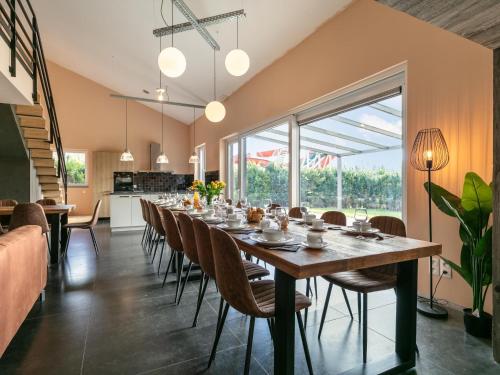 a dining room with a long table and chairs at Ons Huis in Rodenboom