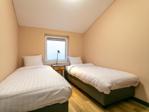 two beds in a room with a window at Ons Huis in Rodenboom