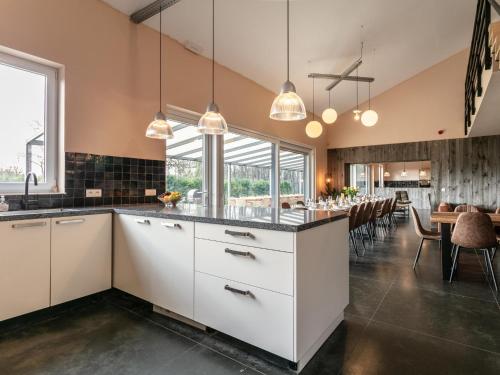 a kitchen with white cabinets and a dining room at Ons Huis in Rodenboom