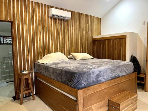 a bedroom with a bed with a wooden wall at Casa Manzanillo Surf in Boca de Ario