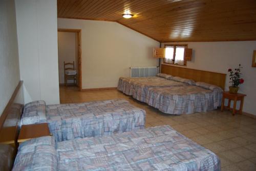 una habitación de hotel con 3 camas en una habitación en Hostal La Cabanya en Setcases