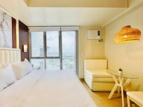 a bedroom with a large white bed and a table at 14 Skyline Serenity in Iloilo City
