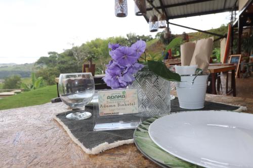a table with a wine glass and purple flowers on it at Adama Biohotel in Calima
