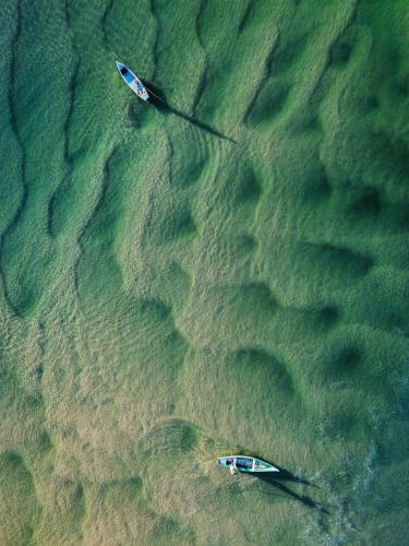 two boats in the water on the beach at Morada das Orquídeas in Guarda do Embaú
