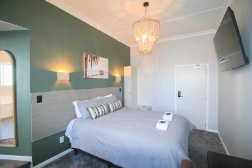 a bedroom with a bed and a chandelier at Whitehouse Hotel in Invercargill