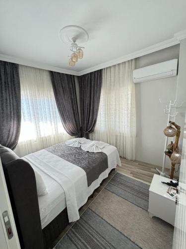 a bedroom with a bed and a window with curtains at Gökçen Home in Pamukkale