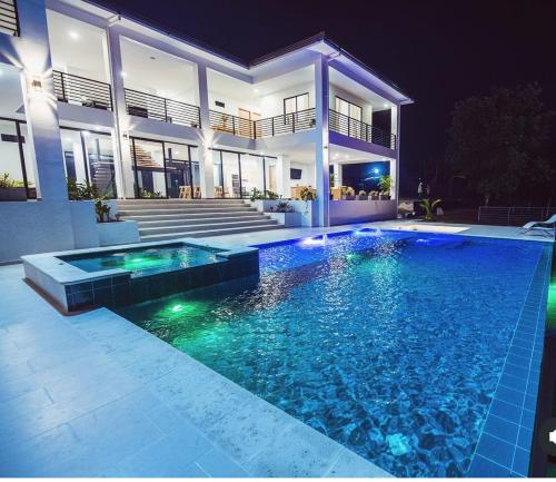 a swimming pool in front of a house at night at Grand Cypress Luxury Home in Montenegro