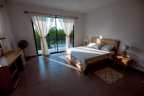 a bedroom with a bed and a large window at Grand Cypress Luxury Home in Montenegro