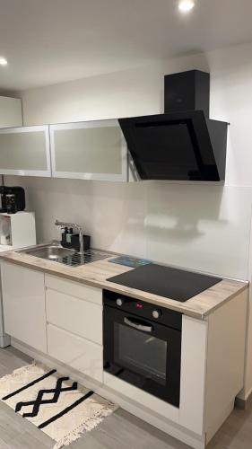 a kitchen with a sink and a stove top oven at Beau Studio in Élancourt