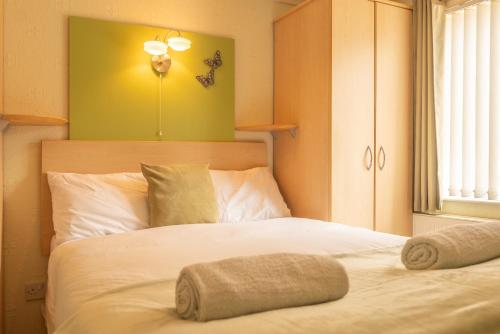 a bedroom with a white bed with a green wall at 5 Ocean View in Woolacombe