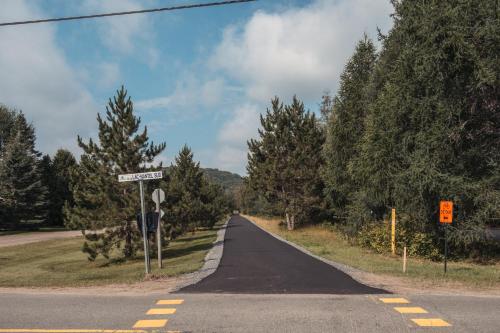 an empty road with a street sign on the side at Loft Exécutif CherLieu de luxe avec vue sur golf et montagnes in Mont-Blanc