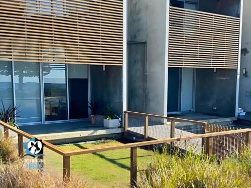 a house with a wooden bench in front of it at New York Loft Style Esplanade Retreat in Encounter Bay