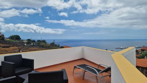 a balcony with chairs and a view of the ocean at Jose's cozy little home in Funchal