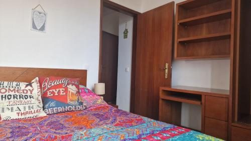 a bedroom with a bed and a wooden cabinet at Jose's cozy little home in Funchal