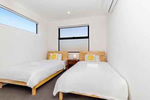 two beds in a room with a window at 4 Bedrooms Lovely House in Clayton Central in Clayton North