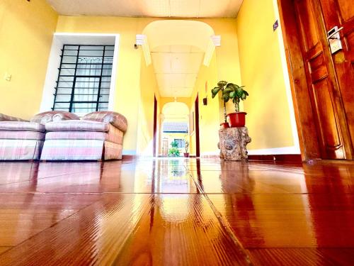 a living room with a hard wood floors and yellow walls at ACCEL Hotel La Quinta in Ibarra
