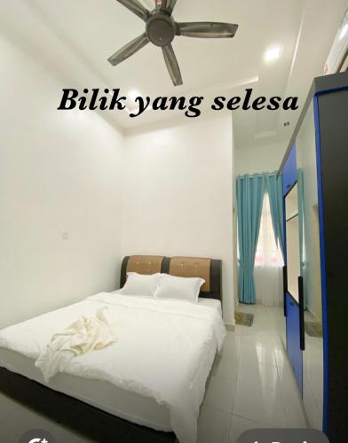 a bedroom with a bed with a ceiling fan at 3A HOMESTAY USTAZ Krai in Kuala Kerai