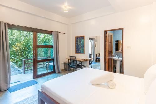 a bedroom with a bed and a large window at Fat Lips Surf Lodge in General Luna