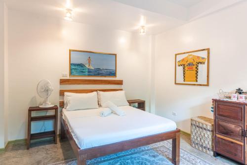 a bedroom with a bed and a dresser at Fat Lips Surf Lodge in General Luna