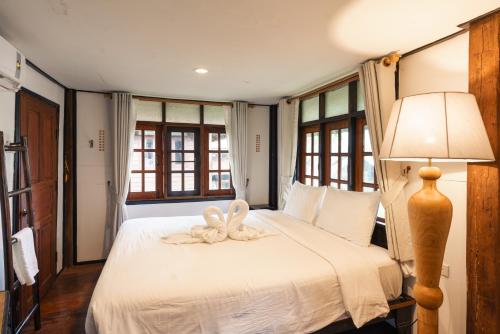 a bedroom with a bed with a flower on it at Pastela Doi Saket Villa & Spa in Ban Pong