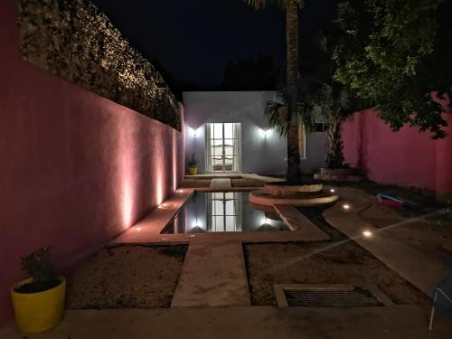 a house with a pool in a courtyard at night at Casa de los Gatos in Mérida