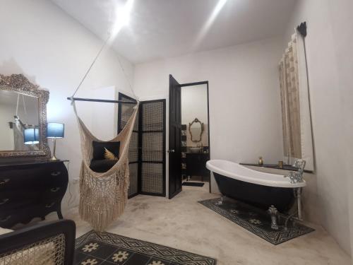 a bathroom with a large tub and a mirror at Casa de los Gatos in Mérida