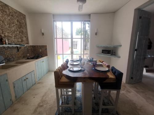 a kitchen with a wooden table with plates on it at Casa de los Gatos in Mérida