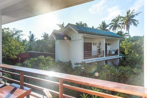 a house with a balcony with a view of it at Fat Lips Surf Lodge in General Luna