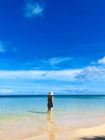 a person standing in the water on a beach at HoshinoHana ~ Beach house~ in Ishigaki Island
