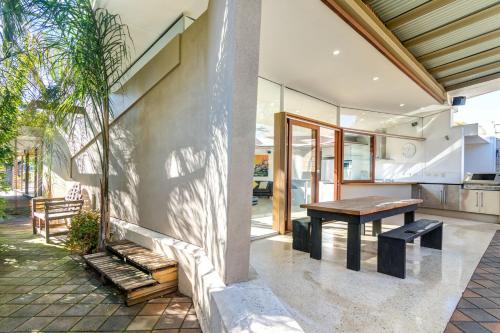a patio with a wooden table and a bench at Dulwich house in Rose Park