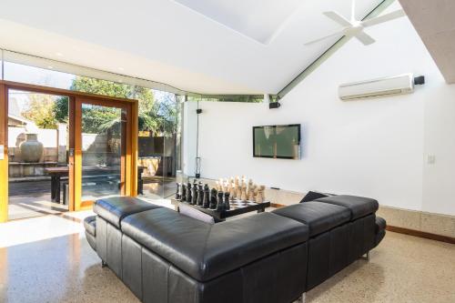 a living room with a black leather couch at Dulwich house in Rose Park