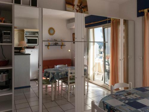 une cuisine et une salle à manger avec une table et une salle à manger dans l'établissement Le Lavandou, studio cabine - 4 pers, plage à 10m, clim, parking, tennis - FR-1-803-64, au Lavandou
