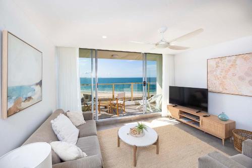 a living room with a couch and a flat screen tv at Ebbtide unit 17 in Forster