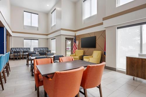 a dining room with tables and chairs and a tv at Holiday Inn Express White House by IHG in White House