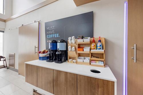 a kitchen with a counter with a cupboard with coffee at Holiday Inn Express White House by IHG in White House